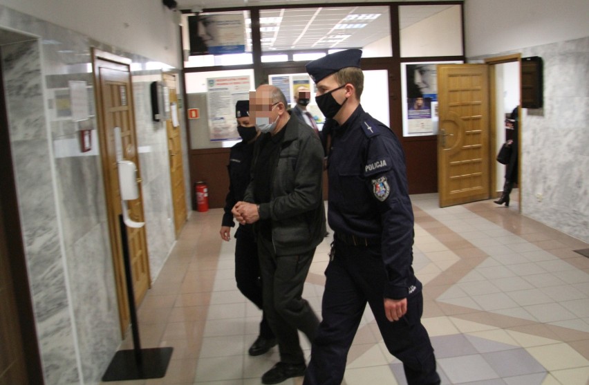 Oskarżony ksiądz w asyście policjantów opuszcza salę rozpraw