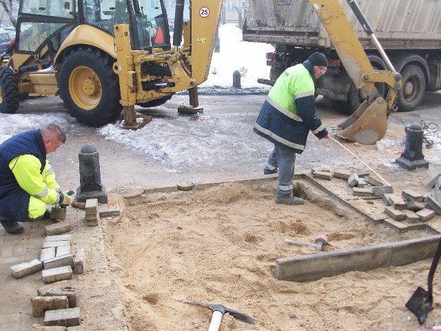 Robotnicy jednej z firm budowlanych naprawiają chodnik, który rozebrano, by naprawić rurę