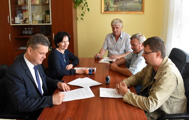 Wójt Opatowca Sławomir Kowalczyk (z lewej) podpisał umowę z wykonawcą na remont dróg gminnych - "powodziówek".