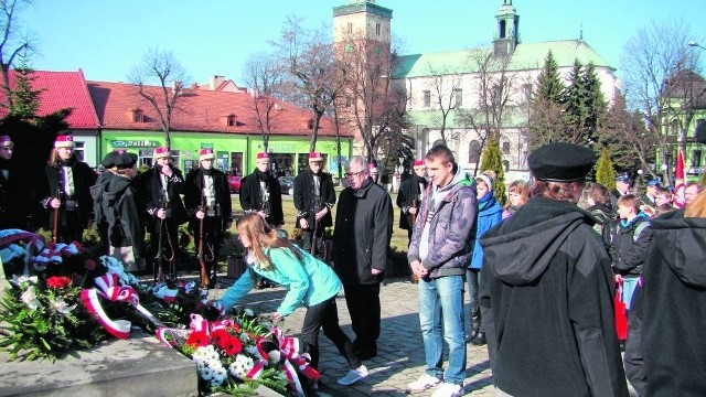 Młodzież składa kwiaty pod pomnikiem na miechowskim rynku