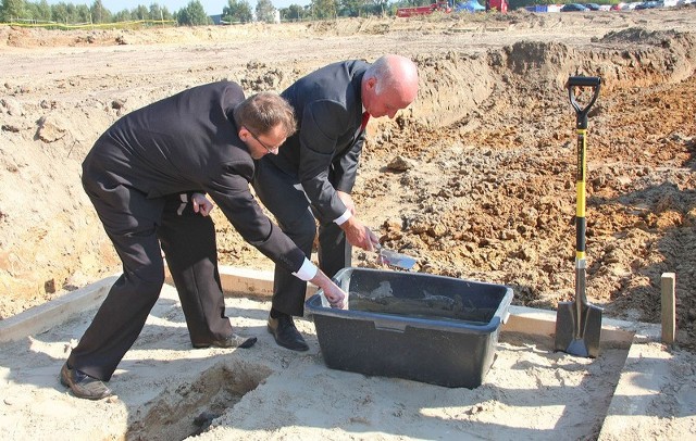 Inwestor Janusz Kosica (z lewej) i prezydent Robert Malinowski wmurowują akt erekcyjny pod budowę serwisu