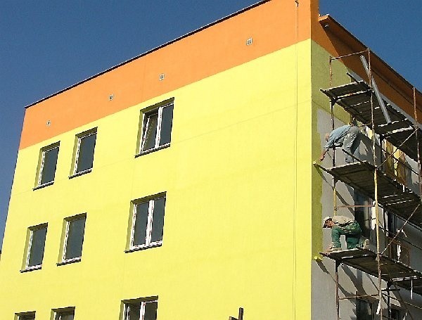 Pracownicy firmy "Budomex" kończą  malować elewację jednego z bloków  komunalnych przy ul. Ptasiej.