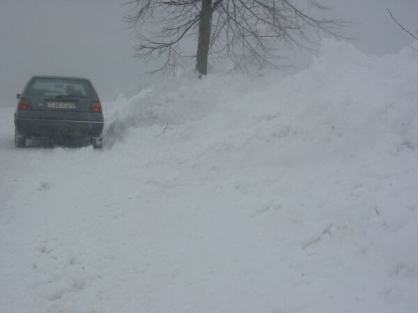 Na drodze Niwiska - Gruszczyn w gminie Krasocin zaspy śniegu sięgają na wysokość samochodu osobowego.