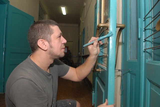Marcin Jaskulski pieczołowicie wykonuje prace konserwatorskie przy jednych z 50 drzwi w Domu Pomocy Społecznej