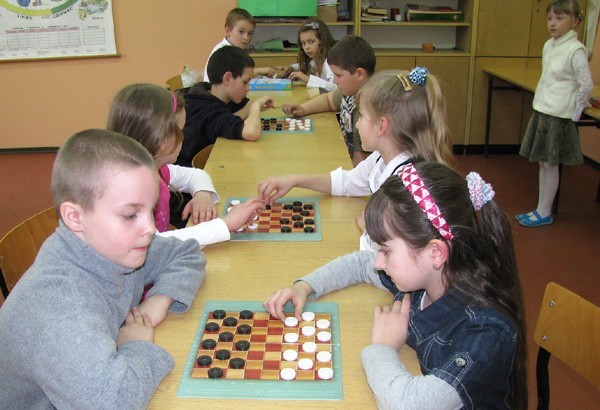 Uczniowie szkoły podstawowej w Mysłakówku nad szachownicami