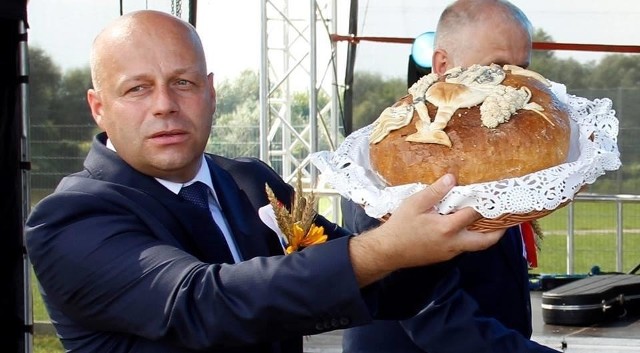 Starosta niżański Robert Bednarz prezentuje dożynkowy chleb, jaki otrzymał od starostów  Lucyny Żuraw i Stanisława Oleksaka