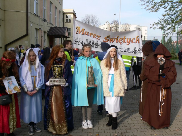 Życie to marsz ku świętości - powiedział ksiądz Marcin Grzyb prowadzący Marsz Wszystkich Świętych w Sandomierzu. W przeddzień uroczystości Wszystkich Świętych uczniowie z sandomierskich szkół i przedszkolaki  przebrane za świętych, przeszli przez miasto w Marszu Wszystkich Świętych. Zwieńczeniem marszu był bal Wszystkich Świętych przy kościele świętego Józefa. ZOBACZ NA KOLEJNYCH SLAJDACH>>>Uczestnicy Marszu wyruszyli sprzed Szkoły Podstawowej nr 4.  Organizator wydarzenia  ksiądz Marcin Grzyb przypomniał, że marsz organizowany jest  po raz trzeci. Uczestników powitała także dyrekcja sandomierskiej "czwórki". - Mam wrażenie, że marsz staje się tradycją naszej szkoły i wpisuje się powoli w harmonogram wszystkich uroczystości czy imprez szkolnych - powiedziała przed wymarszem Izabela Witkowska, zastępca dyrektora Szkoły Podstawowej nr 4 w Sandomierzu. - Dziękuję  siostrom i księżom za przekazanie wam wiedzy o świętych, o czym świadczą wasze piękne stroje. Dziękuję także rodzicom za przygotowanie strojów.  Uczestnicy Marszu nieśli relikwie świętych. W korowodzie szedł święty Stanisław Kostka, patron dzieci i młodzieży, święty Paweł, święta Barbara, święta Jadwiga, Szedł   Anioł Stróż, błogosławiony ksiądz Rewera. Nie mogło zabraknąć  Trzech Króli. Uczestnicy Marszu Wszystkich Świętych prowadzeni przez  Straż Miejską w otoczeniu wolontariuszy- porządkowych  ze śpiewem ustach  przeszli  ulicą Słowackiego w kierunku kościoła Świętego Józefa. Po konferencji na temat świętości, na placu przy kościele odbył się Bal Wszystkich Świętych. Były gry, zabawy  i tańce integracyjne. Dla uczestników przebranych za świętych organizatorzy przygotowali niespodzianki.