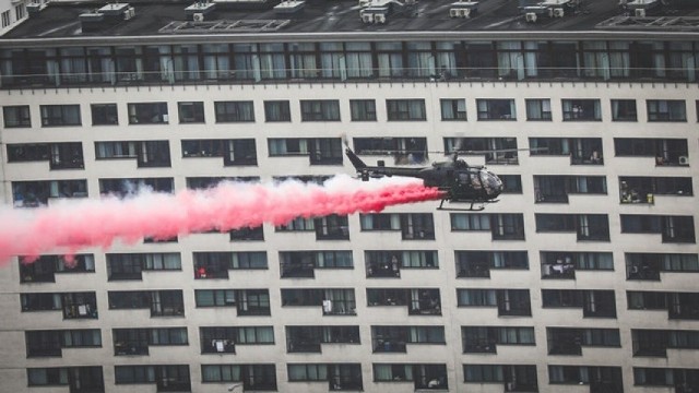 Helikopter nad Warszawą - widać biało-czerwony dym wypuszczany z maszyny