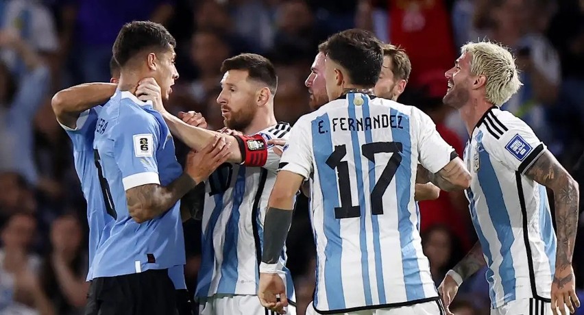 Lionel Messi chwyta urugwajskiego obrońcę Mathiasa Oliverę...