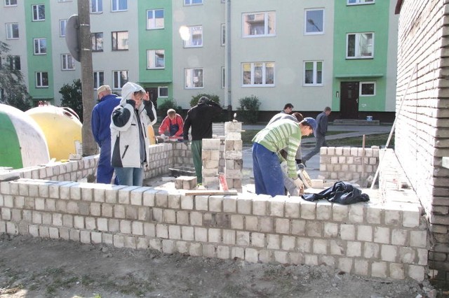 Uczniowie z klasy murarskiej w ramach praktyk stawiają altanę śmietnikową przy ulicy Staffa.
