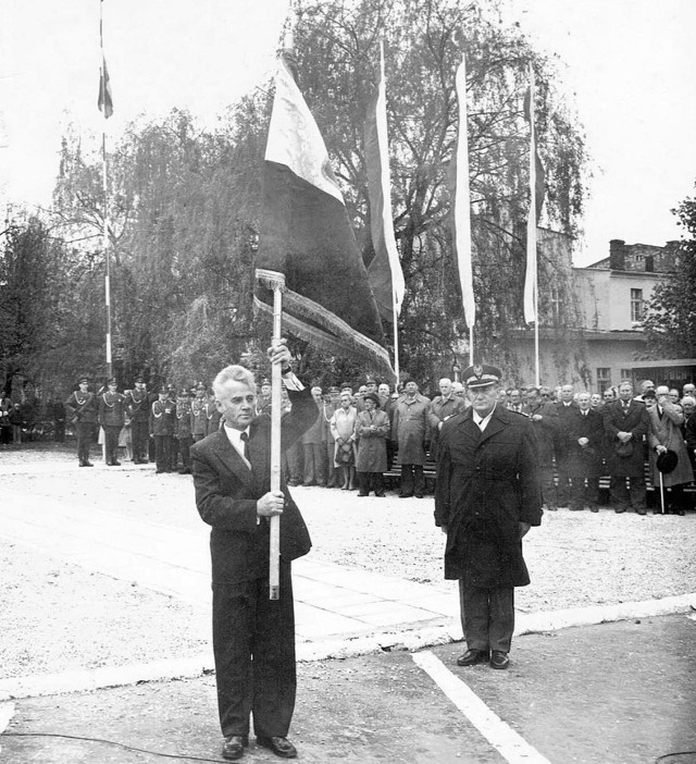 To zdjęcie archiwalne z 12 maja 1985 r. Na pierwszym planie Jan Dudziak podczas podniosłej uroczystości w rynku, jako przewodniczący prezydium miejskiej rady narodowej, prezentuje nowy sztandar miejski. W tym dniu Mogilno - decyzją Rady Państwa - zostało uhonorowane Krzyżem Grunwaldzkim III klasy za czyny bohaterskie jego mieszkańców w walce zbrojnej z okupantem hitlerowskim