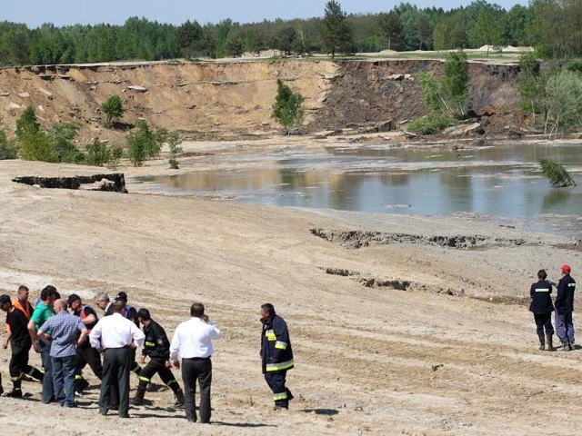 Tysiące ton ziemi i piasku osunęły się do wody, porywając ze sobą dwie spycharki i człowieka uwięzionego w jednej z nich.