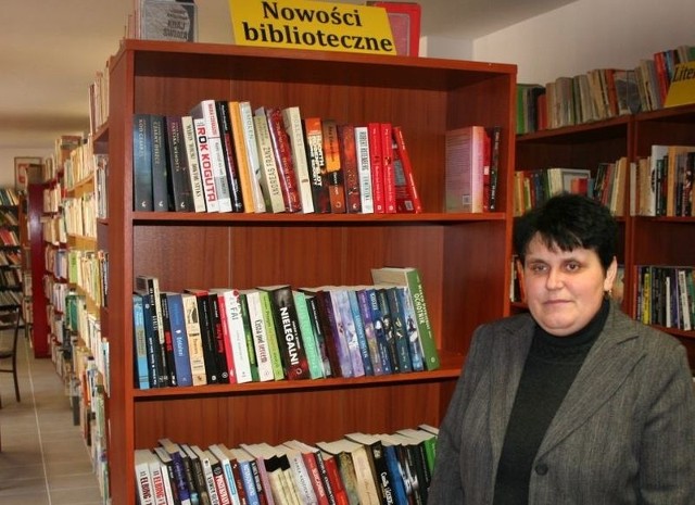 Elżbieta Rostkowska, kierownik biblioteki z dumą pokazuje półkę z nowościami