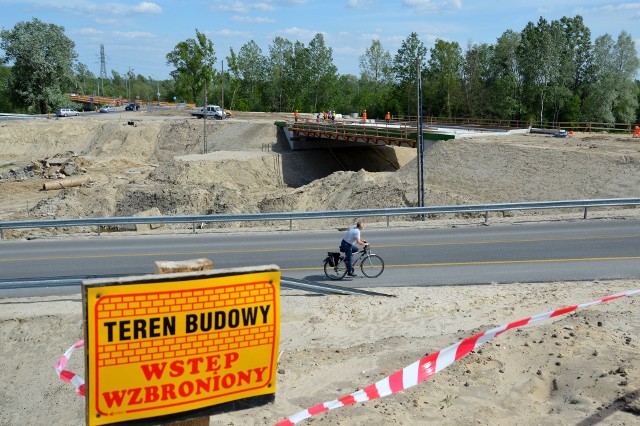 Rowerzysta jedzie objazdem, w tle budowa wiaduktu w ciągu ulicy Czarnieckiego