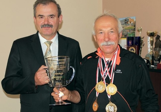 Andrzej Szczepanik prezentuje puchar i medale za wygrane w Road Trophy. Gratuluje &#8211; starosta kazimierski Jan Nowak.