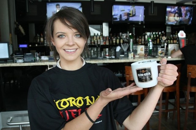 Olga Podsiadło z restauracji Gin-Ger prezentuje koszulkę i kubek, jakie mogą zdobyć kibice Korony Kielce.