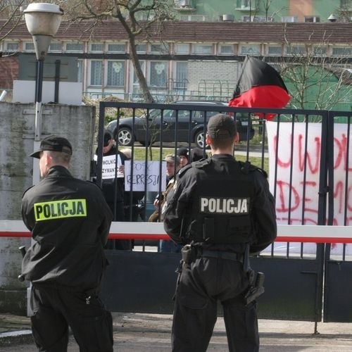 Policjanci ochraniający wjazd do komendy.