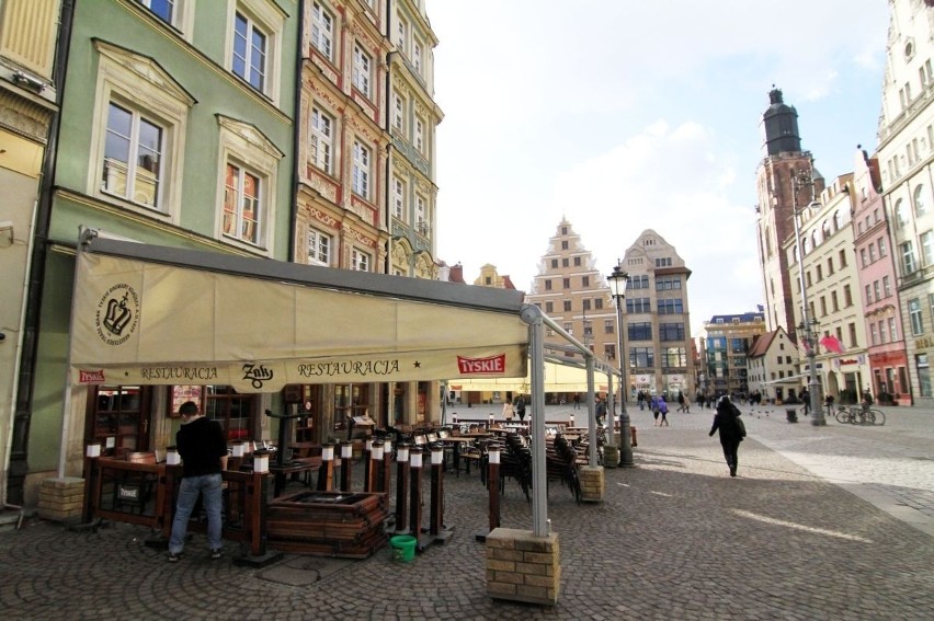 Wrocław: Początek sezonu ogródków letnich w Rynku. Stoi tylko kilka, mało kto w nich siada