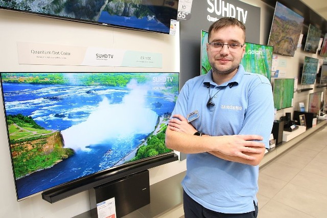 Łukasz Miernik, sprzedawca w salonie Samsunga w Galerii Echo w Kielcach prezentuje telewizor, przy zakupie którego można kupić w Czarny Piątek model UE32k4100 tylko za jedną złotych.