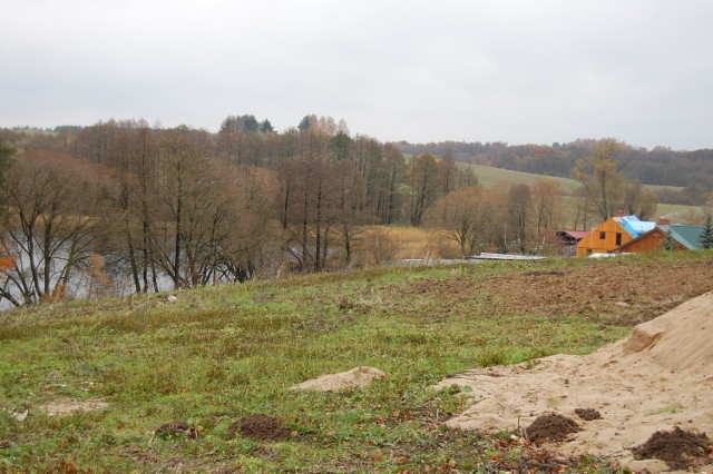 Jezioro Okra w Drawsku Pomorskim. Na pierwszym planie działka, którą gmina sprzedała prywatnym właścicielom na cele turystyczne. Dalej widać stanicę Sławomira Gręziaka, a jeszcze dalej są gminne działki przeznaczone pod budownictwo jednorodzinne. Uchwała