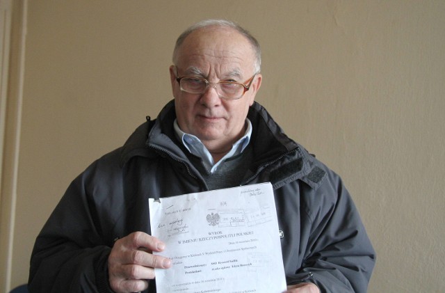  Bogusław Kołomański pokazuje wyrok sądu z 2010 roku.