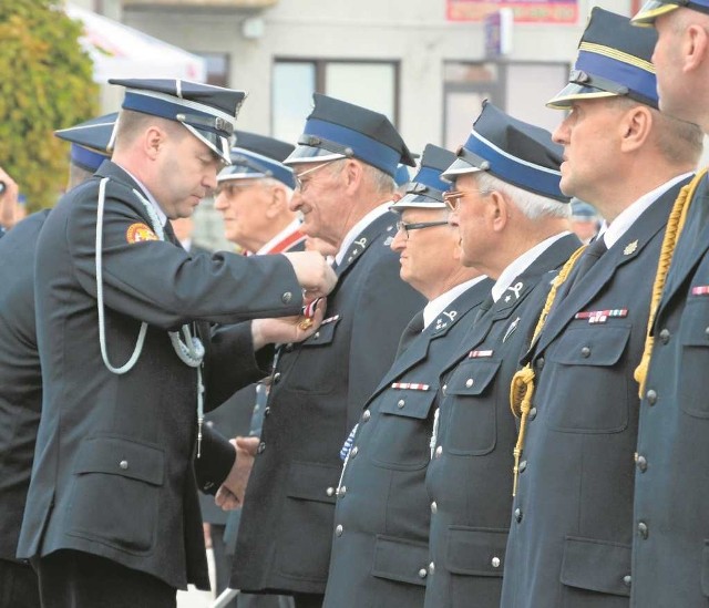 Strażaków odznacza prezes zarządu powiatowego ZOSP Marcin Gaweł