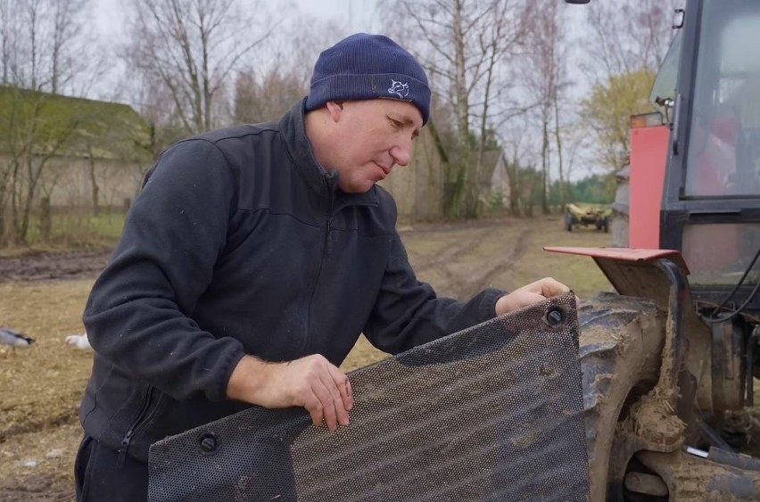Andrzej montuje osłony silnika w wyremontowanym ciągniku