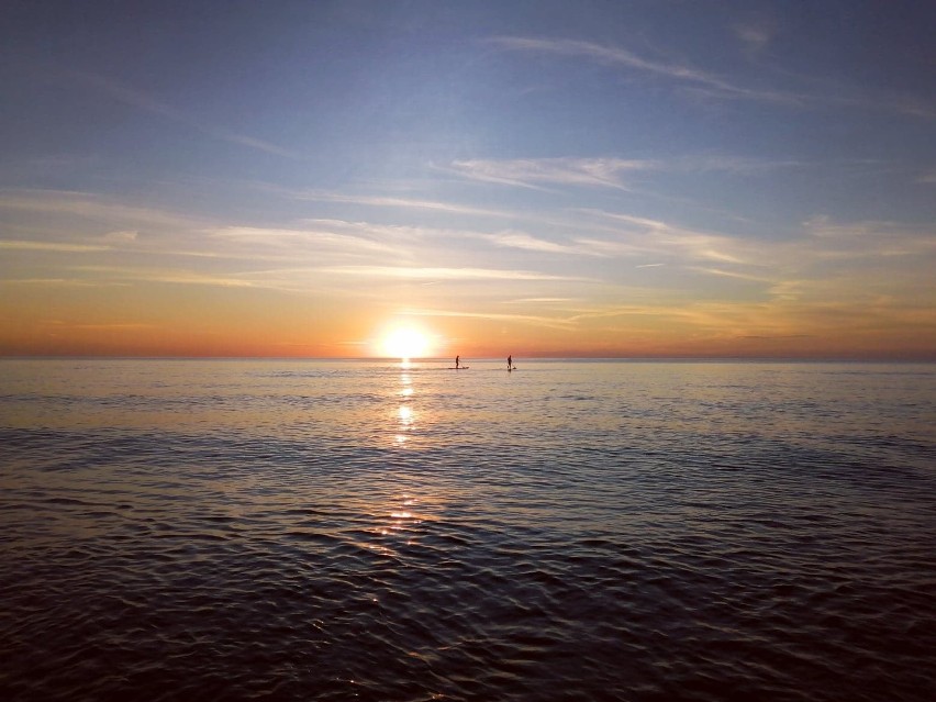 Motoparalotnie i deski SUP nad morzem na tle zachodzącego słońca [ZDJĘCIA]