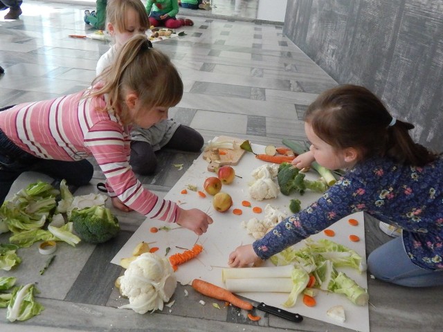 Dzieci z owoców i warzyw budują wymyślone miasto