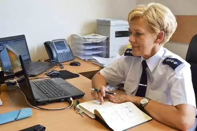 Asp. szt. Anna Kozłowska przy swoim stanowisku pracy, pełnym bieżących informacji