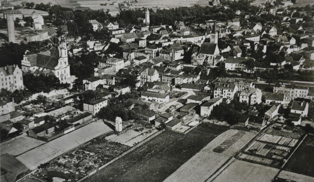 Zdjęcie Olesna z lotu ptaka na pocztówce z 1942 roku. Na ujęciu widać wszystkie oleskie wieże: kościołów św. Michała, Bożego Ciała i Ewangelickiego, wieżę na ratuszu (zburzoną w 1945 roku ) oraz wieżę ciśnień.