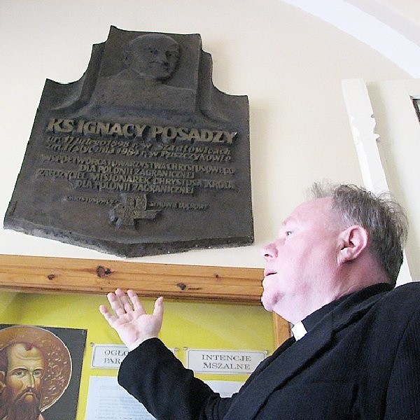 Ks. proboszcz Ireneusz Oliwkowski przed tablicą poświęconą ojcu Ignacemu Posadzemu