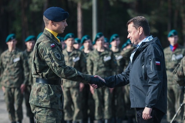 Chęć pokazania grupy z jak najlepszej strony, hart ducha oraz radość z wyników poszczególnych konkurencji. To tylko niektóre z emocji, jakie towarzyszyły kilkuset młodym ludziom podczas rywalizacji na żagańskim poligonie.Tegoroczna, czwarta już edycja Centralnego Zlotu Klas Mundurowych dobiegła końca. Podczas tych kilku niezwykle zaciętych, październikowych dni współzawodnictwa, młodzież w mundurach przelewała pot, aby móc pokazać swoją wartość, charakter. Jednym z założonych celów było między innymi kształtowanie u młodzieży umiejętności i cech charakteru niezbędnych do współdziałania w zespole. Mimo, iż nie wszystkim udało się stanąć na medalowym podium, to już na starcie mogli uważać się za wygranych, bowiem przypadł im zaszczyt reprezentowania swojego miasta, regionu, województwa. Prócz najważniejszych bohaterów tego kilkudniowego wydarzenia – uczniów klas o profilu wojskowym, w dzisiejszej ceremonii zakończenia zlotu udział wziął minister obrony narodowej, Mariusz Błaszczak. Głównym wyróżnieniem za zwycięstwo w IV Centralnym Zlocie Klas Mundurowych był puchar Ministra Obrony Narodowej. Trofeum to ma charakter przechodni i podlegać będzie przekazaniu w następnych latach zwycięzcom kolejnych edycji Centralnego Zlotu Klas Mundurowych. Podsumowanie końcowe zaciętej walki w ramach punktowanych konkurencji marszobiegu, strzelania i wybranych elementów musztry nie były zaskakujące. O miejscu na pudle decydowały małe punkty, a różnice w klasyfikacji generalnej były niemal wyrównane. W wyniku emocjonującej rywalizacji, na najwyższym miejscu uplasowała się klasa Zespołu Szkół Ekonomicznych i Mundurowych im. gen. Władysława Andersa w Chełmie. Dwa kolejne miejsca z przypadły kolejno młodzieży z  Zespołu Szkół w Górowie Iławeckim z województwa warmińsko-mazurskiego oraz Zespołu Szkół nr 2 im. Sybiraków w Nowym Sączu.„Jeśli zdecydujecie się na służbę w Wojsku Polskim to otwierają się przed wami bardzo konkretne perspektywy. Perspektywy służby Polsce.” – podkreślił podczas spotkania z młodzieżą minister obrony narodowej.  Minister Błaszczak spotkał się także z polskimi żołnierzami, zaangażowanymi w przygotowanie i zabezpieczenie tegorocznej edycji zlotu, jak również z reprezentantami amerykańskiej Pancernej Brygadowej Grupy Bojowej. Przedsięwzięcie zorganizowane zostało przez Departament Edukacji, Kultury i Dziedzictwa Ministerstwa Obrony Narodowej oraz Dowództwo Generalne Rodzajów Sił Zbrojnych, a praktycznym wykonawcą była 11. Lubuska Dywizja Kawalerii Pancernej, 23 Śląski pułk artylerii oraz jednostki wspierające poszczególne zagadnienia zlotu.W tegorocznej edycji IV Centralnego Zlotu Klas Mundurowych wzięli udział uczniowie:- Zespołu Szkół Akademickich im. Obrońców Wisły, Collegium Novum, Kujawskiej szkoły Wyższej we Włocławku – województwo kujawsko-pomorskie,- Zespołu Szkół Ekonomicznych i Mundurowych im. gen. Władysława Andersa w Chełmie – województwo lubelskie,- Zespołu Szkół Transportowo-Mechatronicznych w Skarżysku-Kamiennej – województwo świętokrzyskie,- Zachodniopomorskiego Centrum Edukacji Morskiej i Politechnicznej w Szczecinie – województwo zachodniopomorskie,- Zespołu Szkół Centrum Kształcenia Praktycznego w Bujnach – województwo łódzkie,- Liceum Ogólnokształcącego w Zespole Szkół z oddziałami dwujęzycznymi im. Komisji Edukacji Narodowej w Gogolinie – województwo opolskie,- Lotniczych Zakładów Naukowych we Wrocławiu – województwo dolnośląskie,- XIV Liceum Ogólnokształcącego im. Ryszarda Kaczorowskiego w Białymstoku – województwo podlaskie,- Liceum Ogólnokształcącego w Zespole Szkół nr 1 im. Kazimierza Wielkiego w Mińsku Mazowieckim – województwo mazowieckie,- Zespołu szkół Ponadgimnazjalnych nr 2 im. Tadeusza Kościuszki w Stalowej Woli – województwo podkarpackie,- Zespołu Szkół Technicznych im. Hipolita Cegielskiego w Śremie – województwo wielkopolskie,- Zespołu Szkół Ponadgimnazjalnych nr 2 w Jaworznie – województwo śląskie,- Centrum Kształcenia Zawodowego i Ustawicznego „Elektryk” w Nowej Soli – województwo lubuskie.- Zespołu Szkół w Górowie Iławeckim – województwo warmińsko-mazurskie.- Zespołu Szkół nr 2 im. Sybiraków w Nowym Sączu – województwo małopolskie,- Zespołu Szkół Mechanicznych i Logistycznych w Słupsku – województwo pomorskie.Tekst: por. Krzysztof GoneraZobacz również: 11 Lubuska Dywizja Kawalerii Pancernej świętowała w Zielonej Górze:POLECAMY RÓWNIEŻ PAŃSTWA UWADZE:Medale i wyróżnienia w Czarnej Dywizji