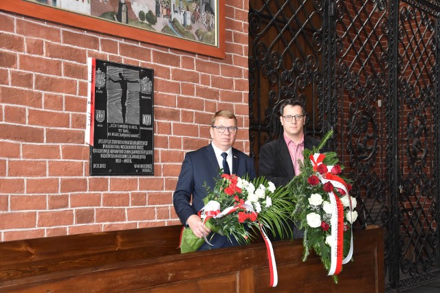 Wicedyrektor Instytutu Pamięci Narodowej prof. Mirosław Golon (z lewej) i radny Karol Maria Wojtasik) przed tablicą w kościele św. Jakuba w Toruniu, upamiętniającą ofiary wydarzeń na Wołyniu