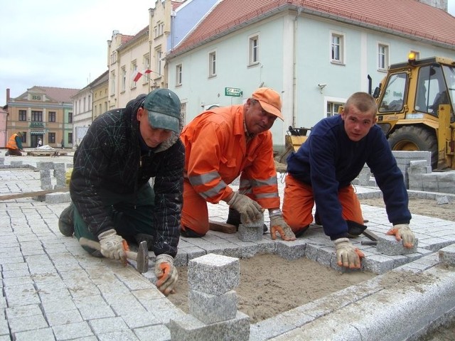 Na Rynku w Nowym Miasteczku Robert, Piotrek i Rafał układają nową kostkę granitową. Niedługo połowa prac wokół ratusza zostanie ukończona.