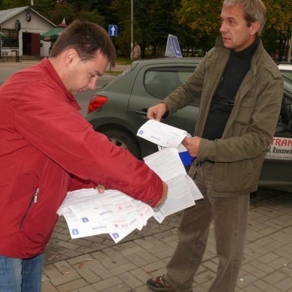 Instruktorzy Maciej Krasoń i Mirosław Wasyl pokazują kartki z zestawieniami ile razy musieli korzystać z serwisu peugeot.