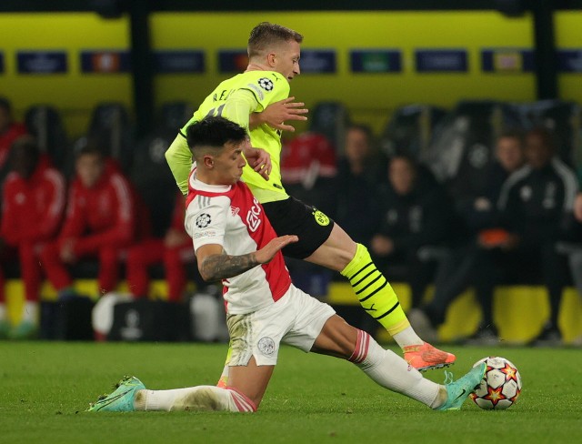 Obrońca Lisandro Martinez walczy o piłkę z atakującym Borussii Dortmund Marco Reusem
