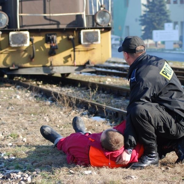 Policjant czeka na przybycie karetki pogotowia do rannego podczas eksplozji bomby maszynisty.