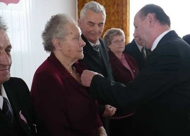 Burmistrz Zdzisław Leks wręcza medale za długoletnie pożycia Helenie i Stanisławowi Miśkiewiczom. 