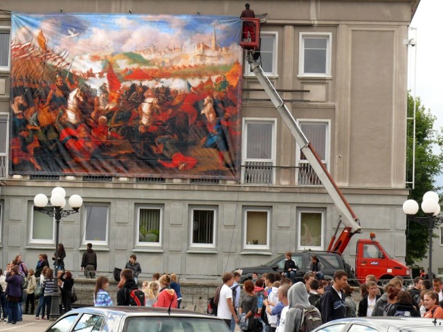 Wieszanie baneru z obrazem przedstawiającym bitwę pod Wiedniem.