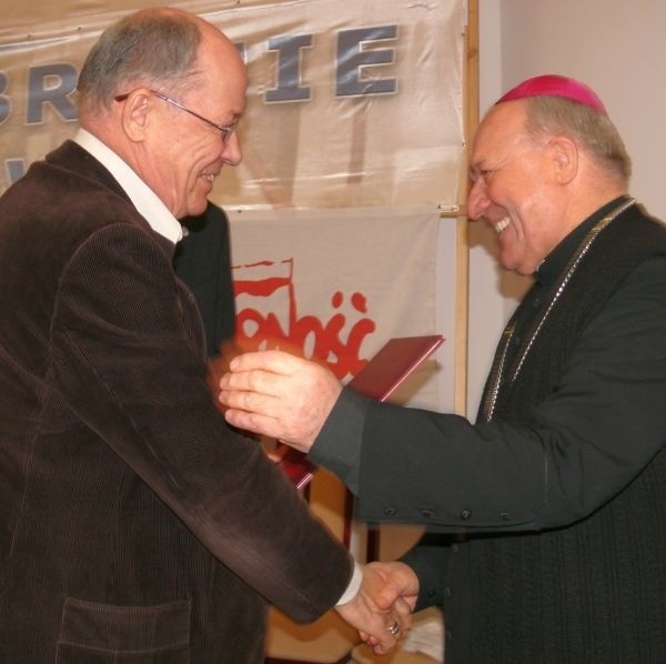 Jacek Smagowicz wręcza tytuł Zasłużony dla NSZZ &#8222;Solidarność&#8221; biskupowi Edwardowi Frankowskiemu.