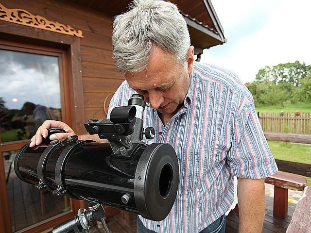 Leszek Długołęcki demonstruje teleskop. Wielu gości chętnie ogląda za jego pomocą nocne niebo nad miejscowością Soce.