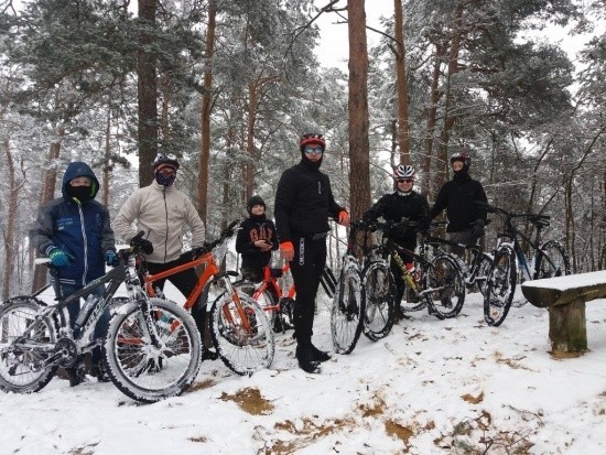 Członkowie kolarskiego klubu w zimowe scenerii