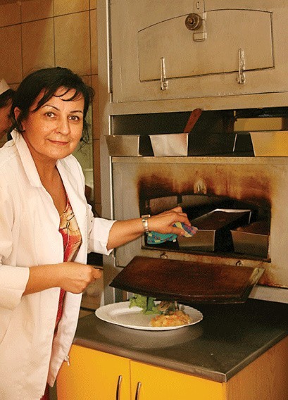 Krystyna Kurpiewska z baru w Handlowcu w Ostrołęce wyjmuje z pieca gorący kugiel, w takie upały jest jeszcze trudniej stać przy piecu