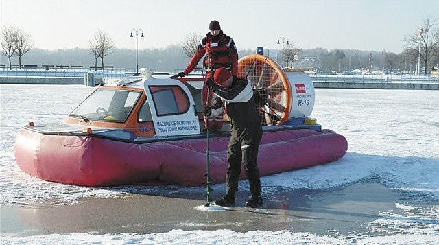 Ratownicy MOPR ubrani w specjalne pianki i kombinezony badają grubość lodu na jeziorach. Na niektórych akwenach ma on już nawet 20 cm grubości.
