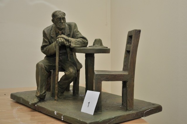 Zwycięski projekt rzeźby profesora Leszka Kołakowskiego przy kawiarnianym stoliku  przygotował Karol Badyna, właściciel Pracowni Rzeźby „forma” z Krakowa.