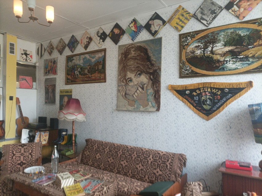 Salon i na ścianie makatki oraz plakaty