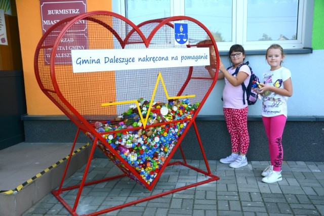Gabrysia i Maja, uczennice daleszyckiej szkoły, systematycznie uzupełniają metalowe serce nakrętkami.