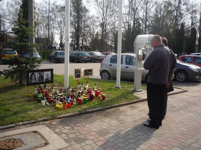 Hajnowianie zapalają znicze i zatrzymują się na chwilę przed portretami ofiar katastrofy.