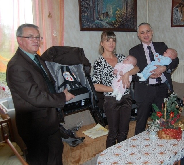 Burmistrz Końskich Michał Cichocki (z prawej) wraz z Edytą Rusek (mamą trojaczków) trzymają na rękach dwójkę maluchów. Wózek &#8211; jako gwiazdkowy prezent &#8211; prezentuje zastępca burmistrza Krzysztof Jasiński.